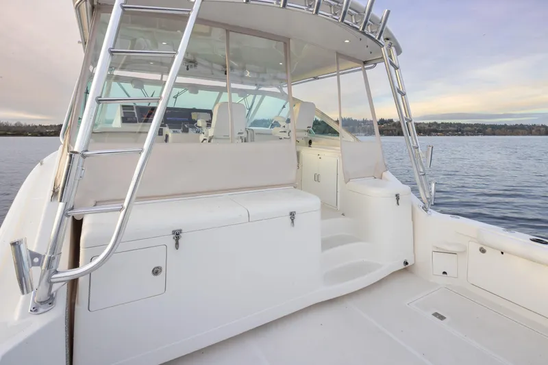 Slide: The Image of 2006 Cabo 40 Express boat interior with seating and ladder on calm water. - 39