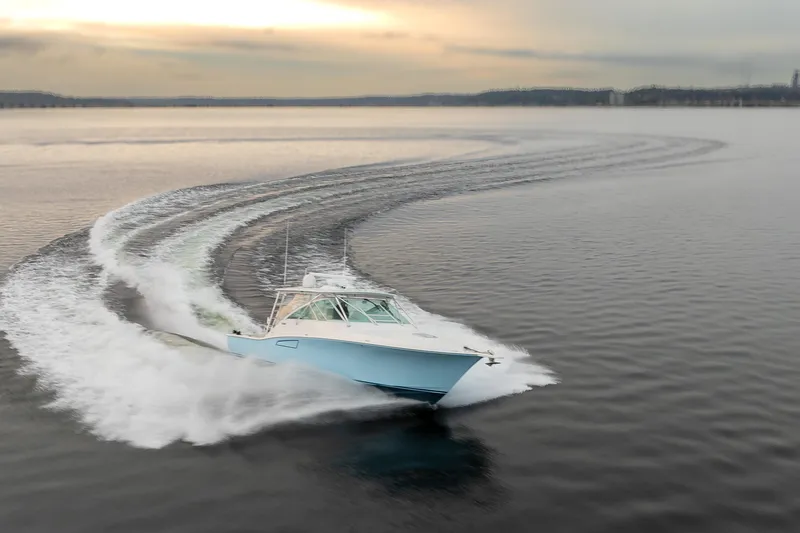 Slide: The Image of 2006 Cabo 40 Express yacht cruising swiftly on open water at sunset. - 44