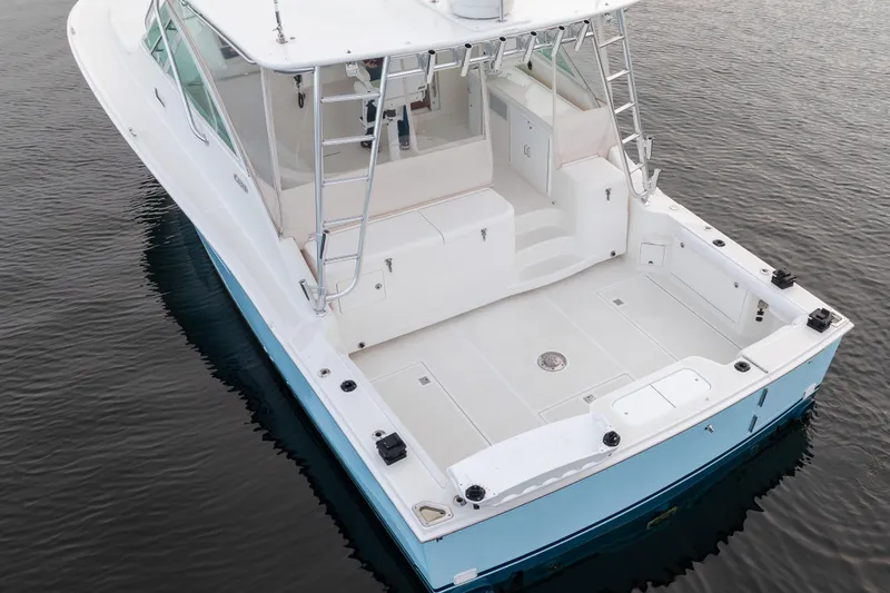 Slide: The Image of 2006 Cabo 40 Express boat on calm water, featuring spacious deck and sleek design. - 8