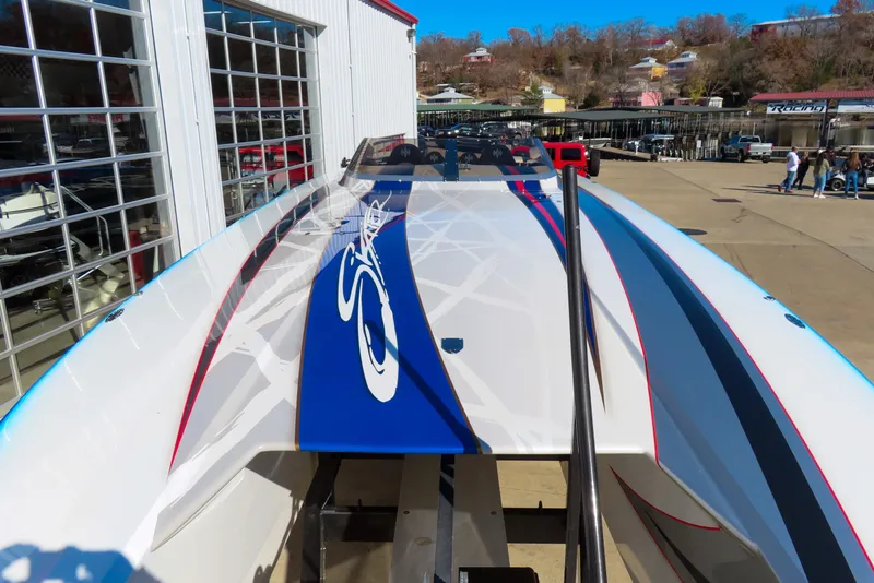 Slide: The Image of 2016 Skater 388 boat with sleek design and vibrant graphics at a marina. - 11