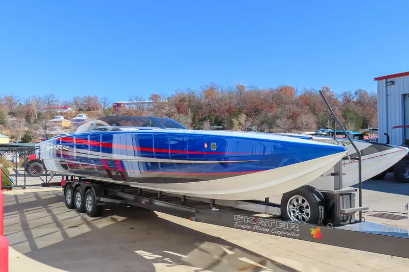 Slide: The Image of 2016 Skater 388 powerboat on trailer, vibrant blue and red design, parked outdoors. - 3