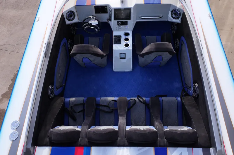 Slide: The Image of 2016 Skater 388 boat interior with blue carpet, modern dashboard, and multiple seats. - 6