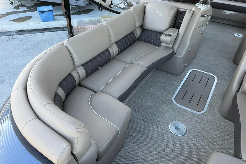 Slide: The Image of 2018 Bennington 25 QSB boat interior with plush seating and carpeted flooring. - 14