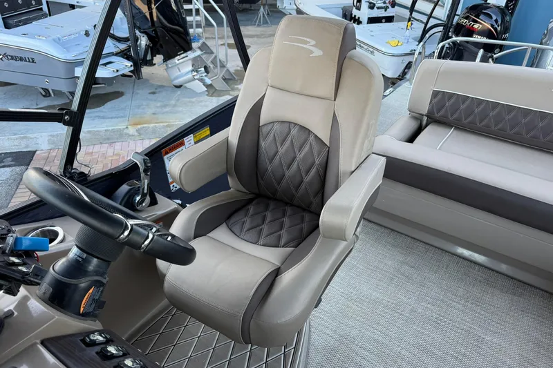 Slide: The Image of Captain's chair and helm of 2018 Bennington 25 QSB boat, featuring luxurious seating. - 17