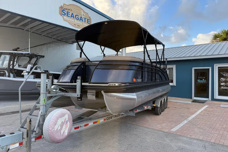 The Image of 2018 Bennington 25 QSB pontoon boat on trailer outside a building. - 2
