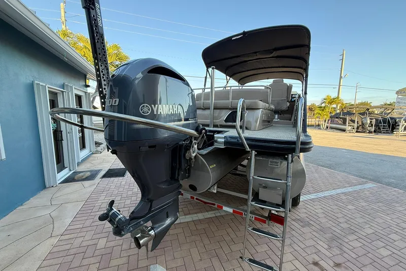 Slide: The Image of 2018 Bennington 25 QSB pontoon boat with Yamaha outboard motor, parked on brick driveway. - 8