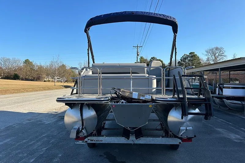 Slide: The Image of 2026 Bentley Pontoons Fish 243 Swingback on trailer, rear view, outdoor setting. - 6
