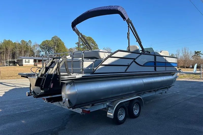 Slide: The Image of 2026 Bentley Pontoons Fish 243 Swingback on trailer, parked outdoors under clear blue sky. - 7