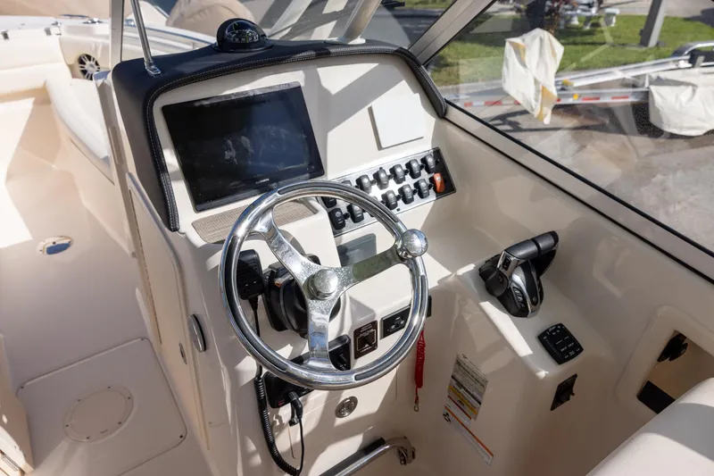 Slide: The Image of 2023 Grady-White Freedom 255 boat helm with steering wheel and control panel. - 11