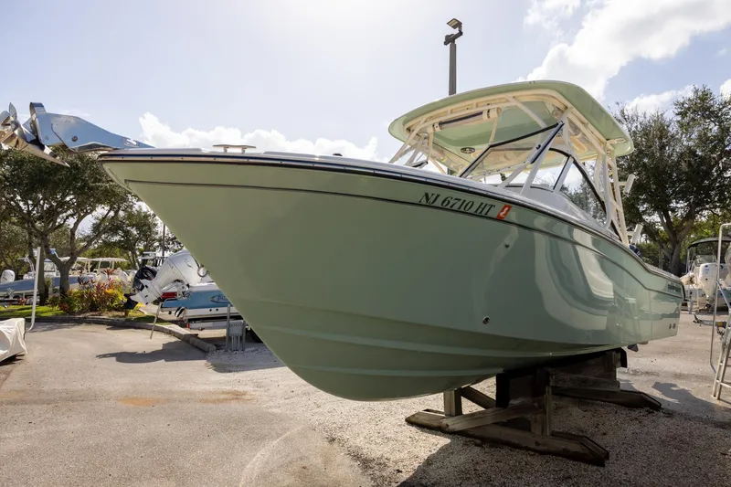 Slide: The Image of 2023 Grady-White Freedom 255 boat on display, side view with trees in background. - 2