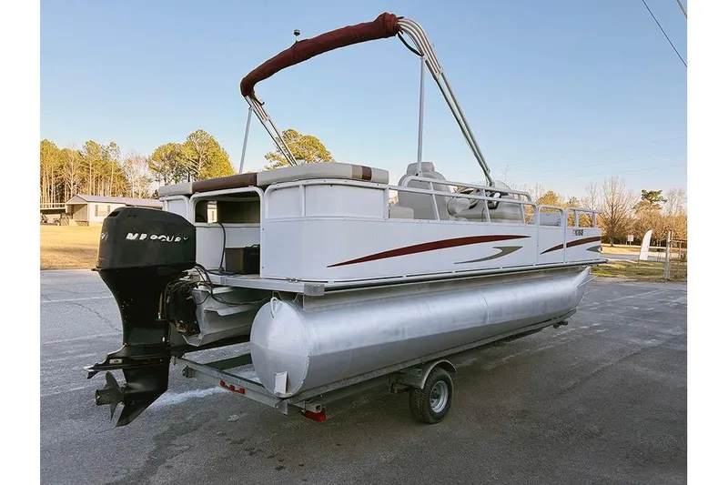 Slide: The Image of 2006 Bentley Pontoons 200 Fish on trailer, featuring outboard motor and canopy, parked outdoors. - 8