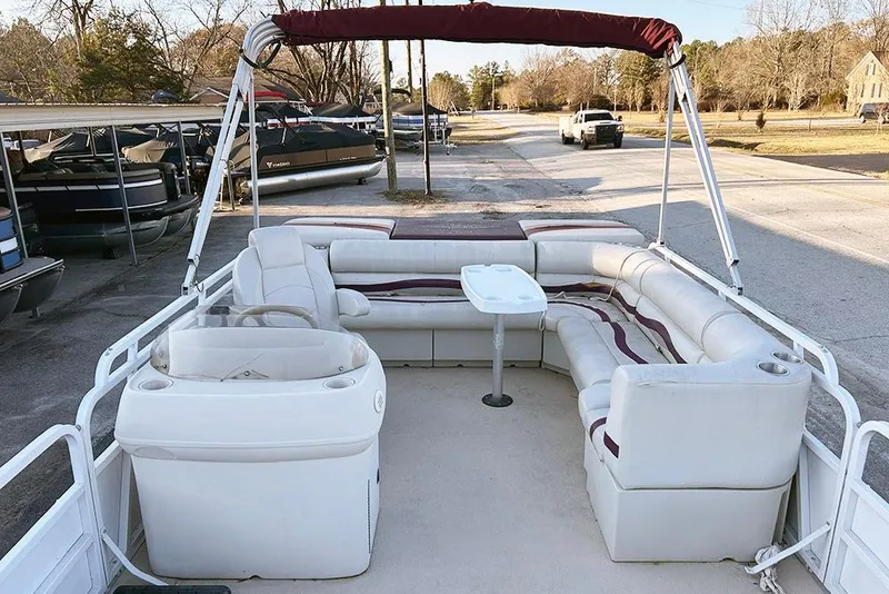 Slide: The Image of 2006 Bentley Pontoons 200 Fish with spacious seating and steering console, parked outdoors. - 9