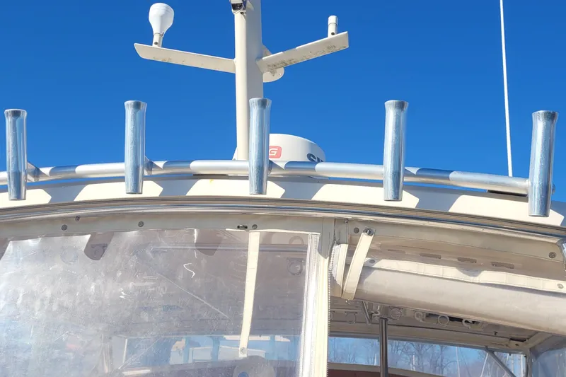 Slide: The Image of 2015 Fortier 30 boat with rod holders and radar, under clear blue sky. - 13