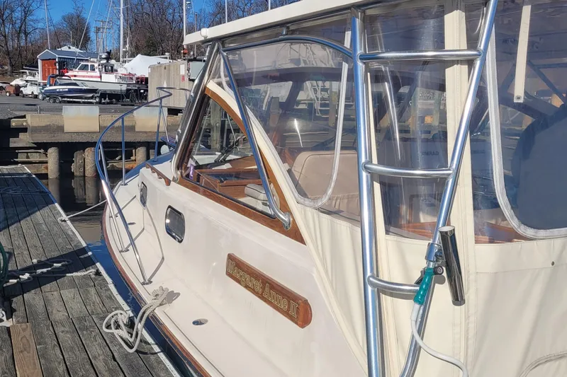 Slide: The Image of 2015 Fortier 30 boat docked at marina, featuring sleek design and clear enclosure. - 9