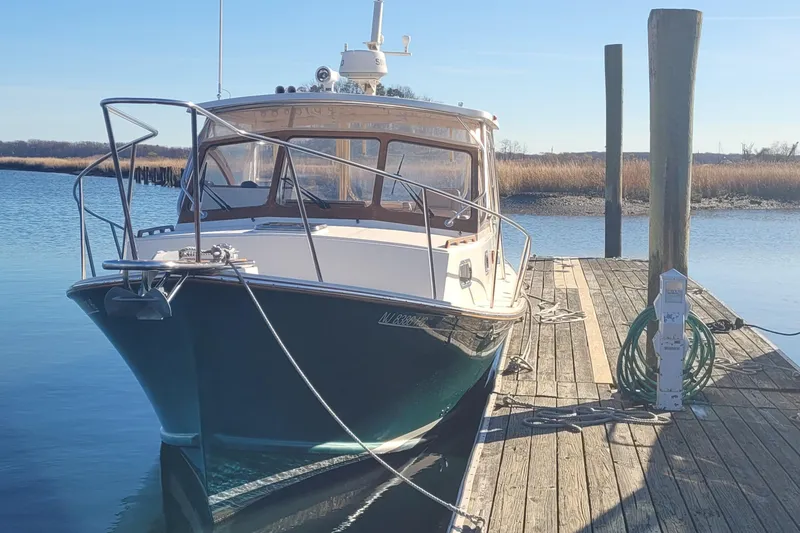 Slide: The Image of 2015 Fortier 30 boat docked, featuring a sleek design and spacious cockpit. - 2