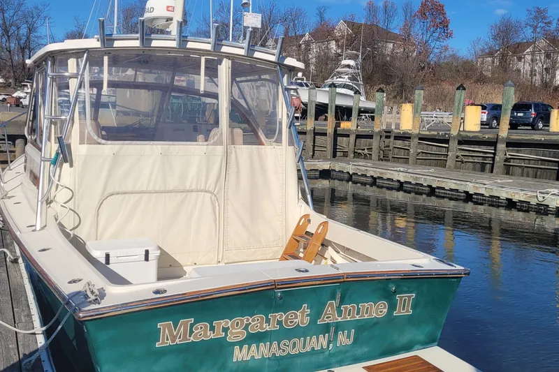 Slide: The Image of 2015 Fortier 30 boat docked, featuring a sleek design and enclosed cabin. - 5