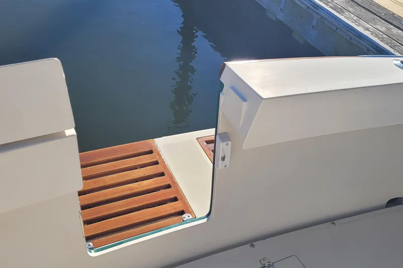 Slide: The Image of Wooden boat ladder, coiled rope, and cleaning tools on a 2015 Fortier 30 deck. - 59
