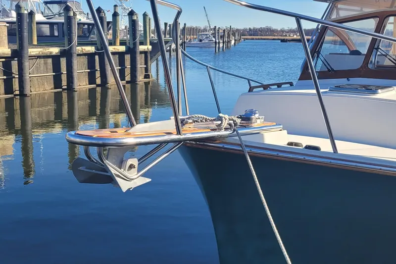 Slide: The Image of 2015 Fortier 30 boat docked by a serene waterfront under clear blue skies. - 6