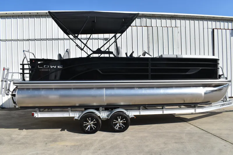 The Image of 2026 Lowe SF 232 Sport Fish pontoon boat on trailer, parked outdoors. - 0