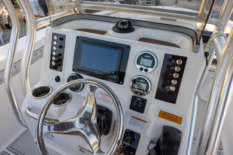 Slide: The Image of 2019 Robalo R202 Explorer boat dashboard with steering wheel and navigation controls. - 10