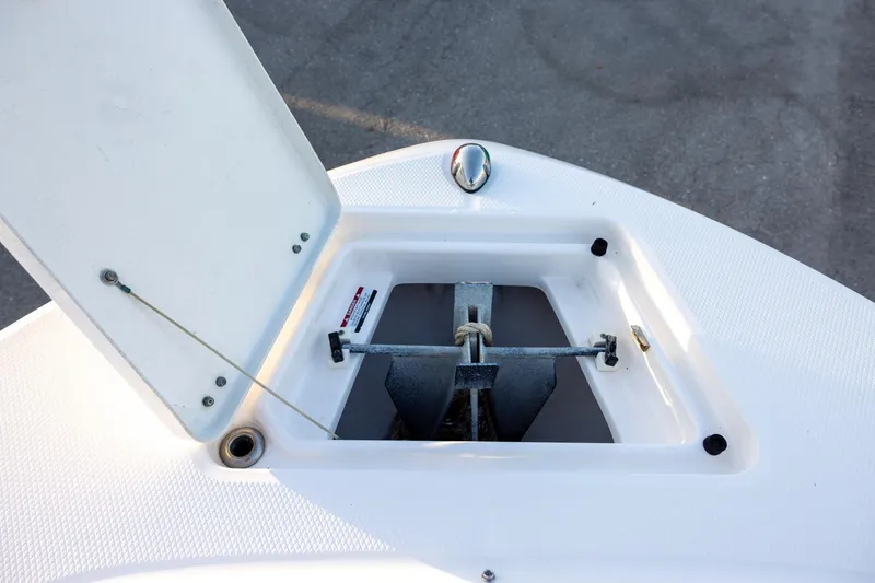 Slide: The Image of 2019 Robalo R202 Explorer anchor compartment with open hatch, showcasing anchor storage. - 13