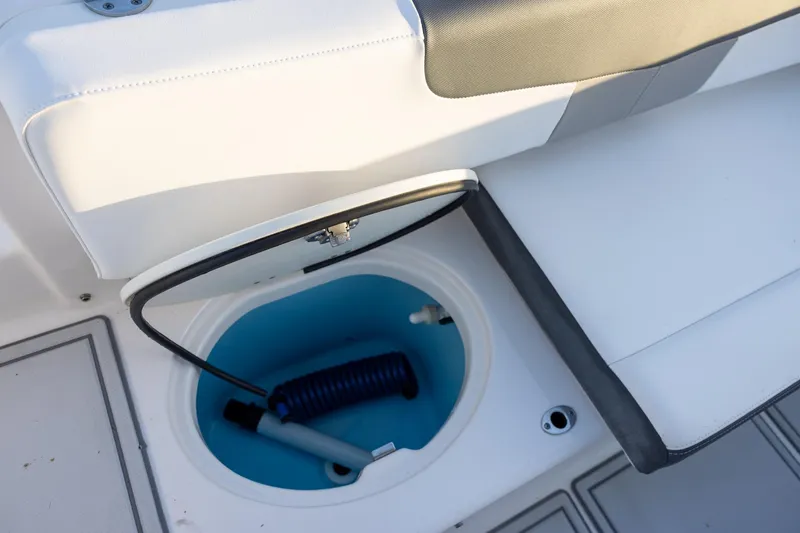 Slide: The Image of 2019 Robalo R202 Explorer boat storage compartment with coiled hose. - 15