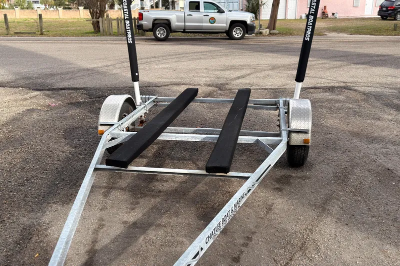 Slide: The Image of Boat trailer for 2017 Carolina Skiff 18 JVX CC on asphalt, with truck in background. - 13