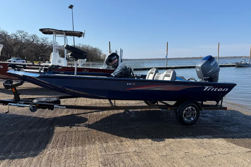 Slide: The Image of 2020 Triton 17 TX boat on trailer by a lakeside dock. - 12