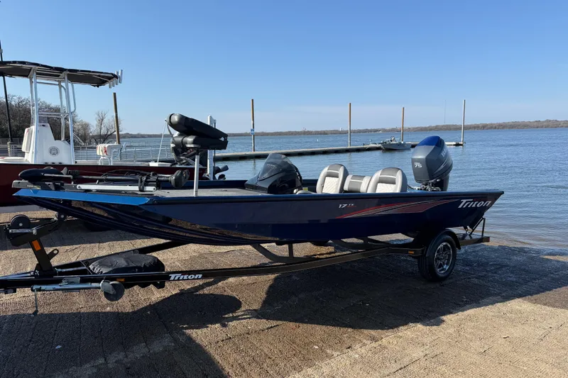 Slide: The Image of 2020 Triton 17 TX boat on trailer by a lake, ready for launch. - 13