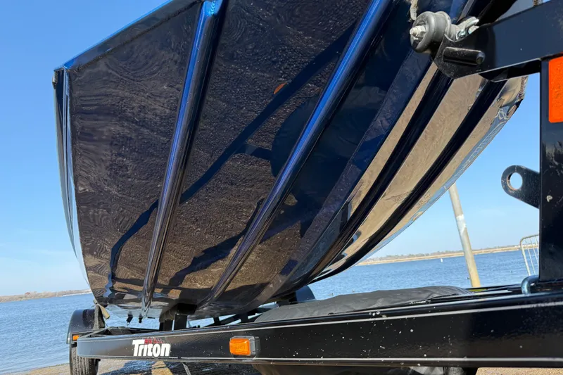 Slide: The Image of 2020 Triton 17 TX boat on trailer by the water, showcasing sleek hull design. - 16