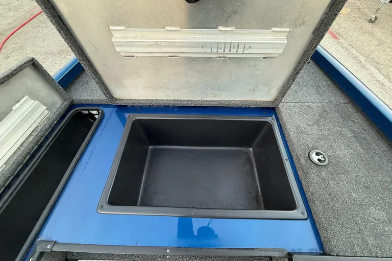 Slide: The Image of Open storage compartment in 2020 Triton 17 TX boat, featuring blue and gray interior. - 41