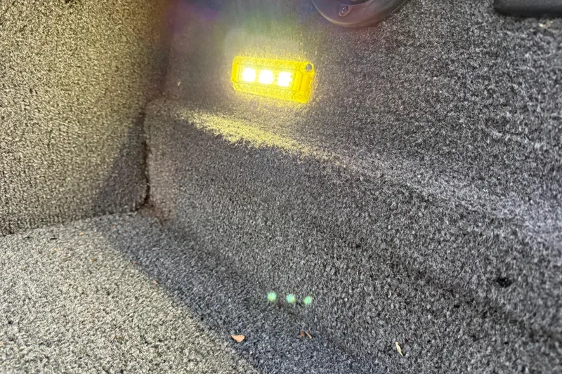 Slide: The Image of Yellow LED light on carpeted interior of 2020 Triton 17 TX boat. - 57