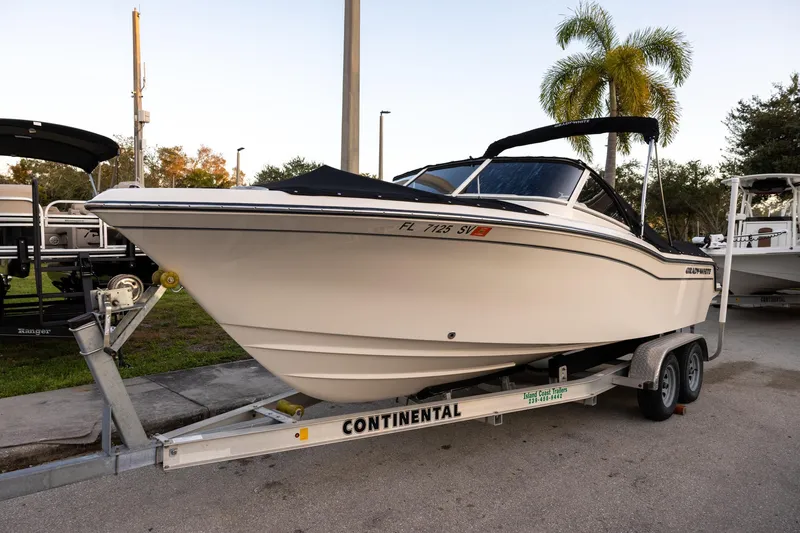 The Image of 2021 Grady-White Freedom 215 boat on trailer, parked outdoors with palm trees. - 1