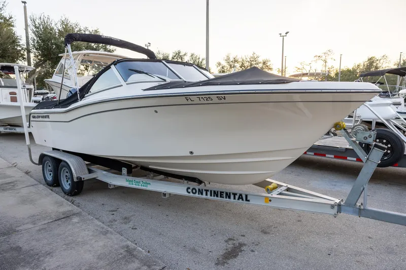 Slide: The Image of 2021 Grady-White Freedom 215 boat on trailer, parked outdoors. - 2