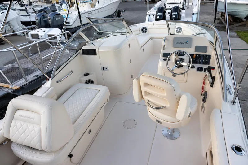 Slide: The Image of 2021 Grady-White Freedom 215 boat interior with helm, seating, and Garmin navigation system. - 5
