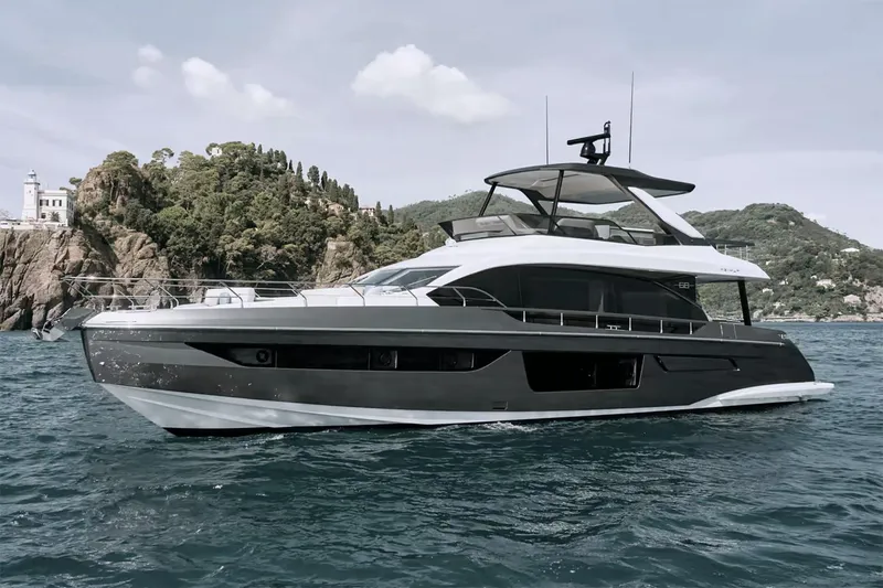 Slide: The Image of Manufacturer Provided Image: 2025 Azimut Fly 68 yacht cruising near a scenic coastline. - 1
