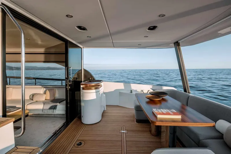 Slide: The Image of Manufacturer Provided Image: Luxurious Azimut Fly 68 yacht interior with ocean view, featuring elegant seating and wooden table, 2025 model. - 4