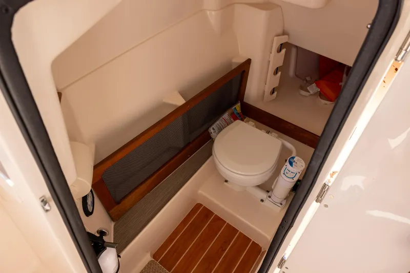 Slide: The Image of 2022 Grady-White Freedom 275 boat interior with compact marine toilet. - 15
