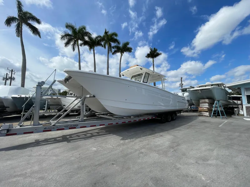 Slide: The Image of 2024 World Cat 400 CC-X boat on a trailer under a blue sky with palm trees. - 1