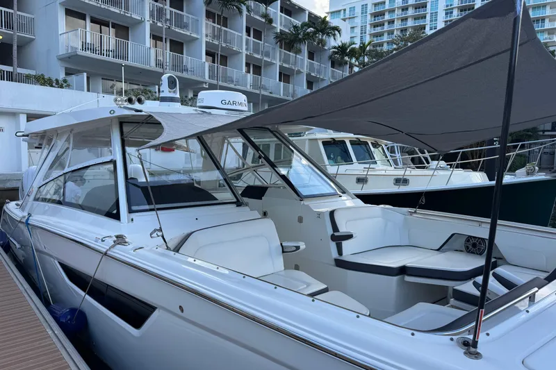 Slide: The Image of 2023 World Cat 400 DC-X boat docked with sunshade, modern design, and comfortable seating. - 11