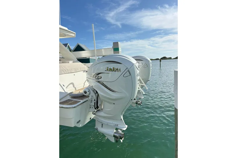 Slide: The Image of Twin Yamaha outboard engines on a 2023 World Cat 400 DC-X boat, docked by the water. - 35