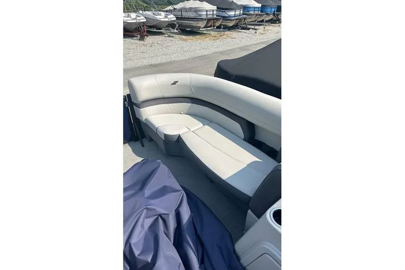 Slide: The Image of 2024 Starcraft EXS 3 Q boat interior with white and gray seating, docked outdoors. - 3