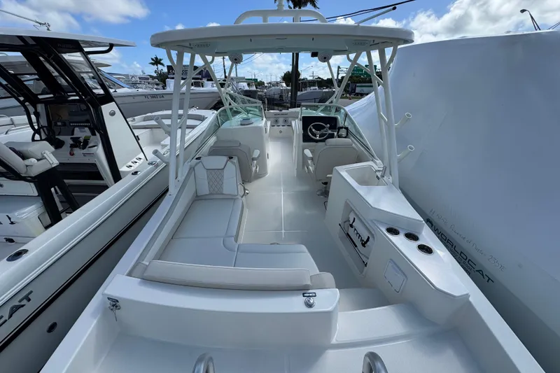 Slide: The Image of 2026 World Cat 230 SD boat interior with seating and steering wheel, docked under blue sky. - 15