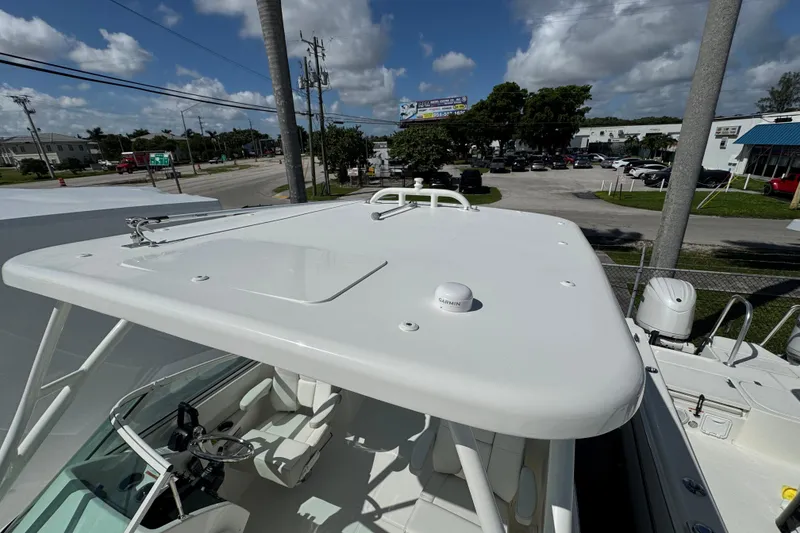 Slide: The Image of 2026 World Cat 230 SD boat with sleek white design, parked outdoors under a blue sky. - 19
