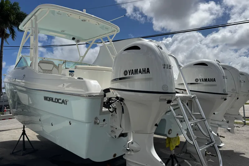 Slide: The Image of 2026 World Cat 230 SD boat with Yamaha engines, docked under a cloudy sky. - 2