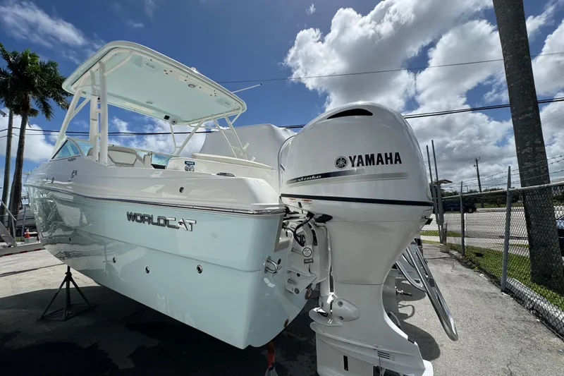 Slide: The Image of 2026 World Cat 230 SD boat with Yamaha engine, parked outdoors under a blue sky. - 6