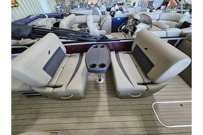 Slide: The Image of 2024 Starcraft CX 23 RL boat interior with beige seating and central table. - 10