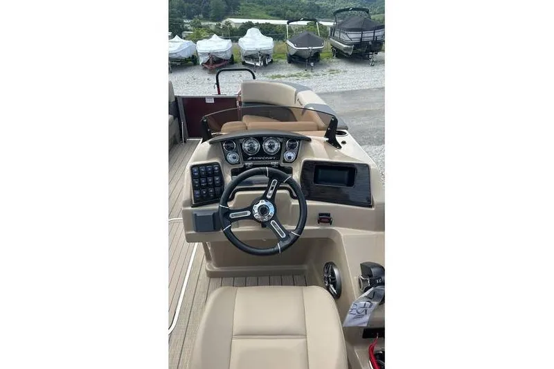 Slide: The Image of 2024 Starcraft CX 23 RL boat dashboard with steering wheel and control panel. - 3