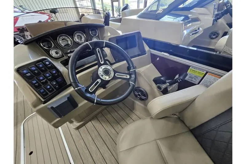 Slide: The Image of 2024 Starcraft CX 23 RL boat dashboard with steering wheel and control panel. - 7