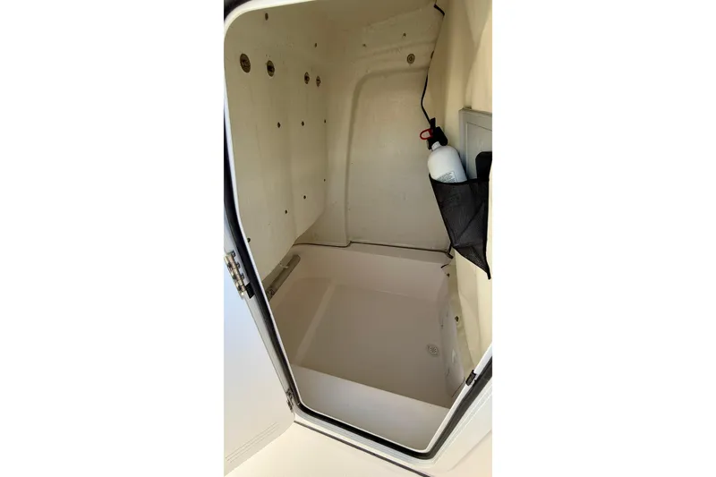 Slide: The Image of 2023 Sea Fox 228 Commander storage compartment with fire extinguisher and netted pocket. - 30